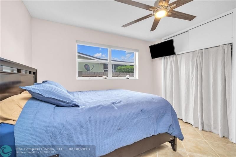 5206 Cleveland Street Hollywood, FL 33021 - Photo 20 of 49 a bedroom with a bed and a chandelier