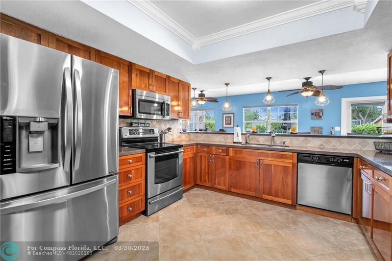 5206 Cleveland Street Hollywood, FL 33021 - Photo 5 of 49 a kitchen with stainless steel appliances granite countertop a refrigerator a stove top oven a sink and dishwasher