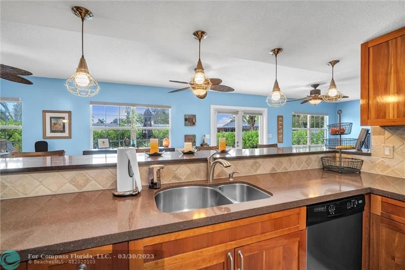 5206 Cleveland Street Hollywood, FL 33021 - Photo 6 of 49 a kitchen with stainless steel appliances granite countertop a sink a stove and a wooden floors