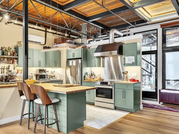 a room with stainless steel appliances kitchen island granite countertop a sink and cabinets