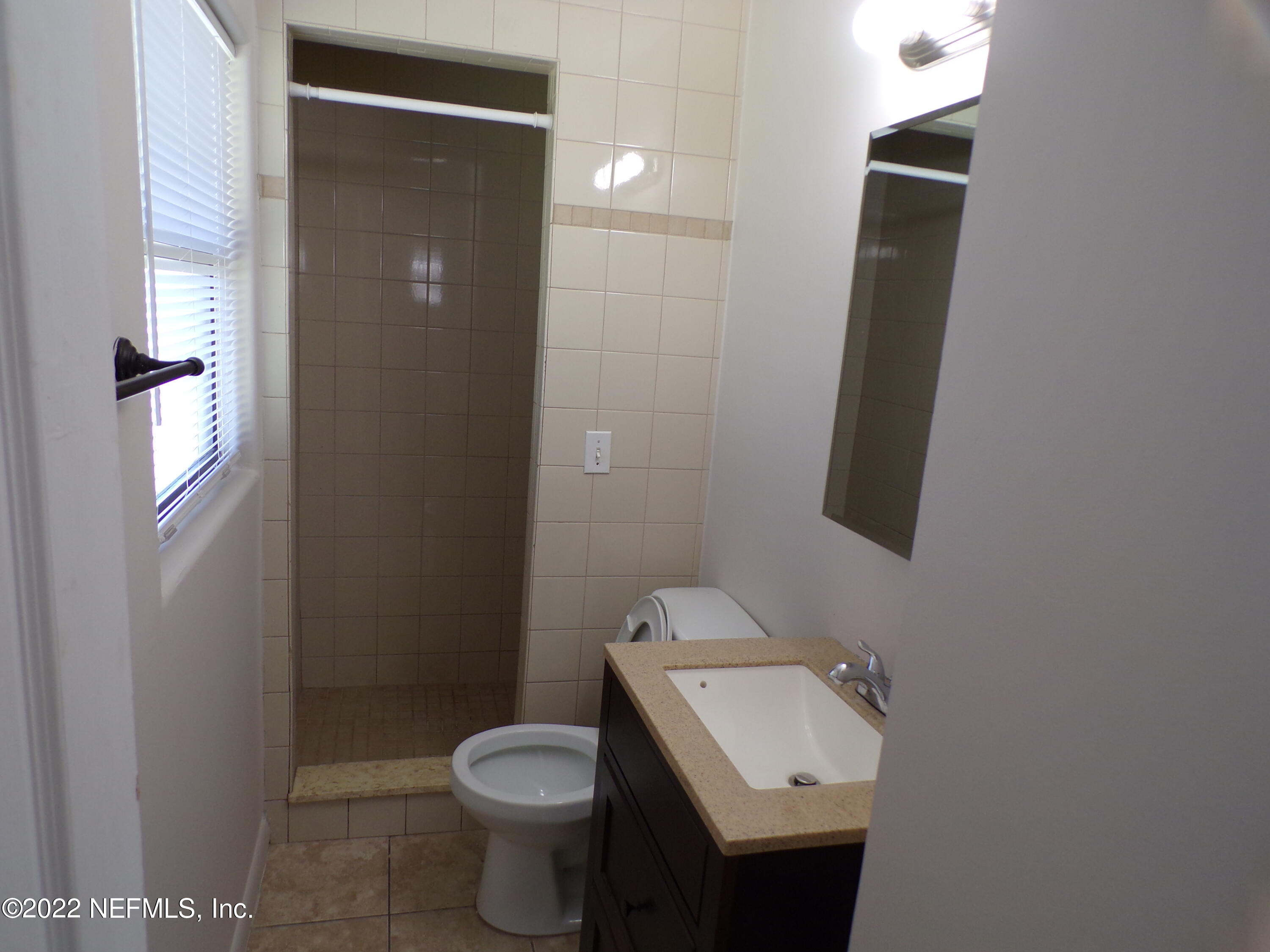 7424 Strato Road Jacksonville, FL 32210 - Photo 13 of 16 a bathroom with a sink and mirror with toilet