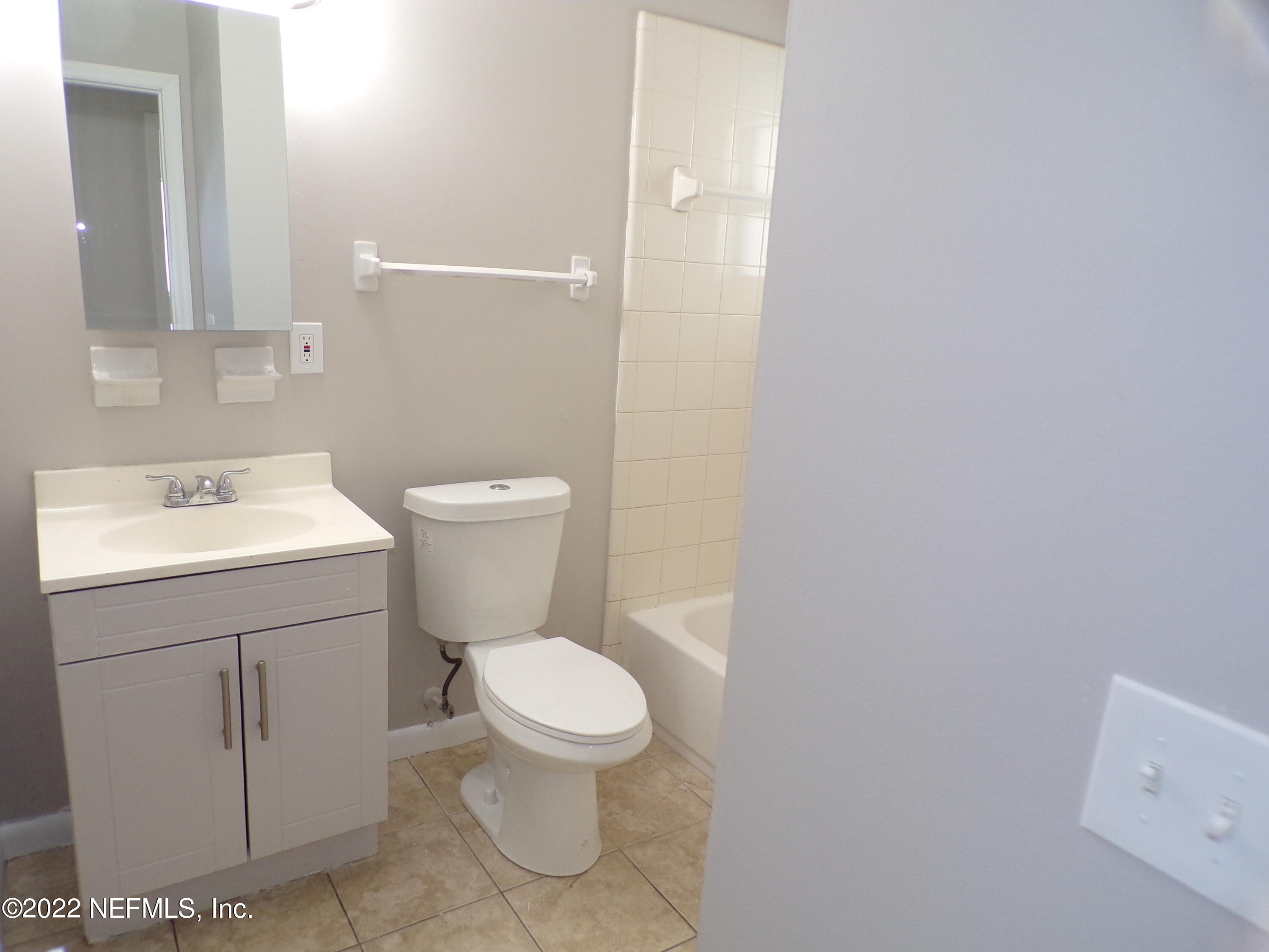 7424 Strato Road Jacksonville, FL 32210 - Photo 14 of 16 a bathroom with a toilet sink and mirror