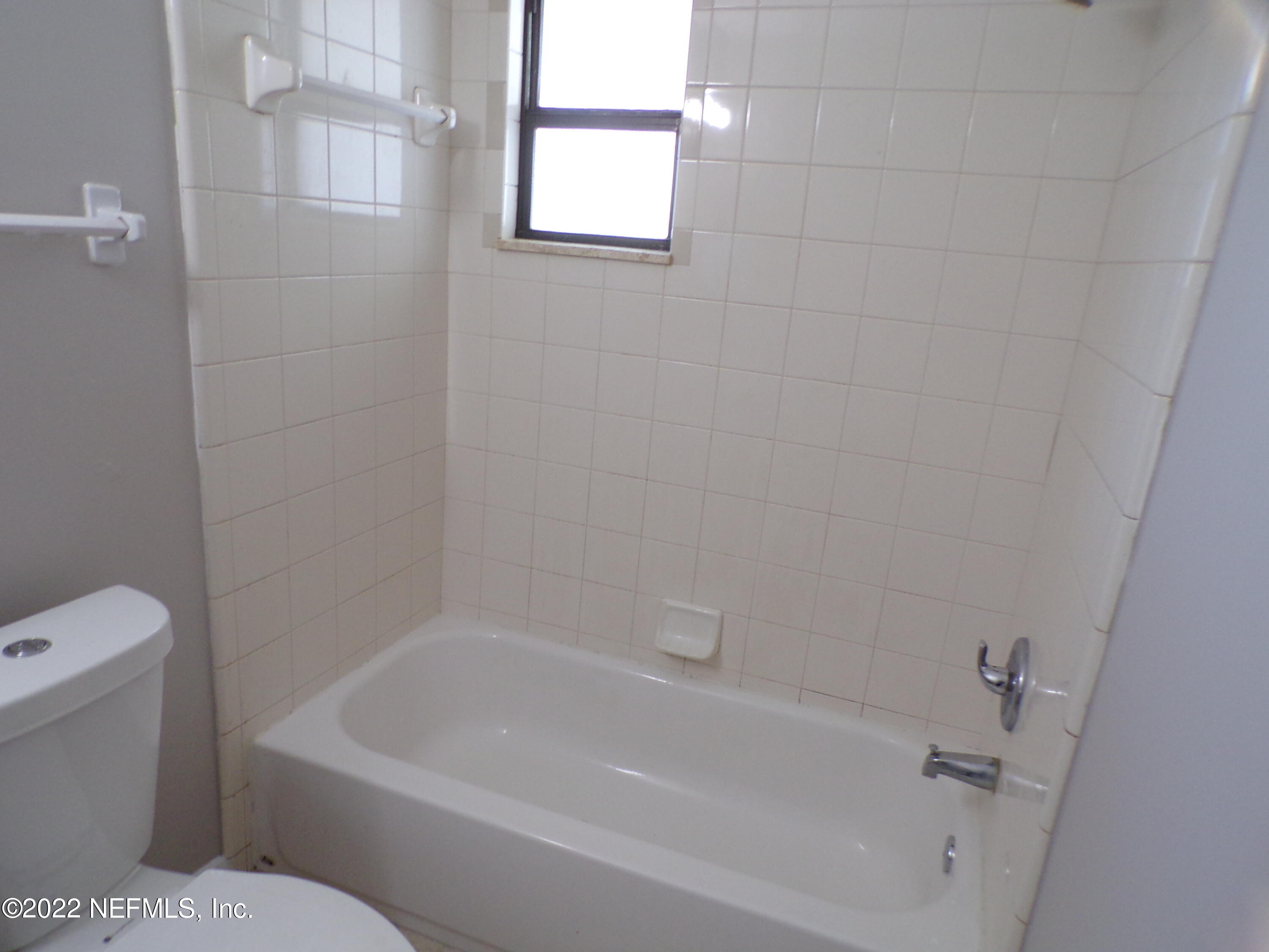 7424 Strato Road Jacksonville, FL 32210 - Photo 15 of 16 a white bath tub sitting next to a white toilet