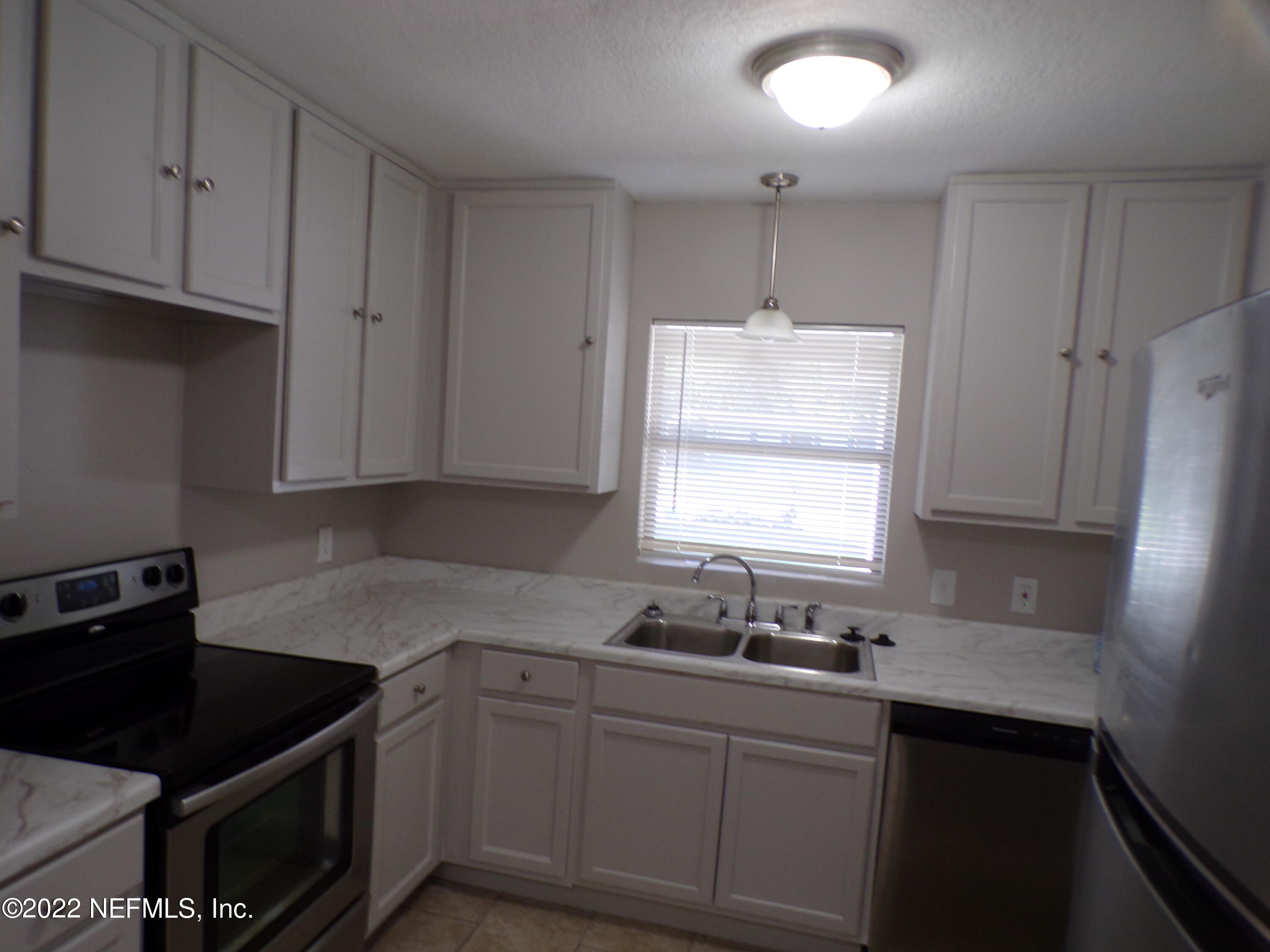 7424 Strato Road Jacksonville, FL 32210 - Photo 5 of 16 a kitchen with granite countertop a sink cabinets and window
