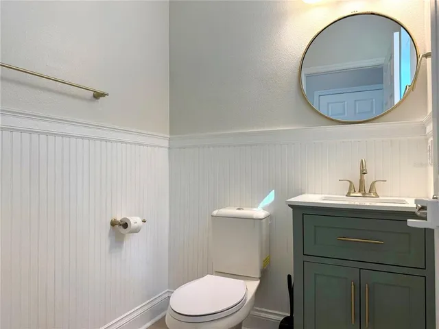 a bathroom with a granite countertop sink a large mirror a and toilet