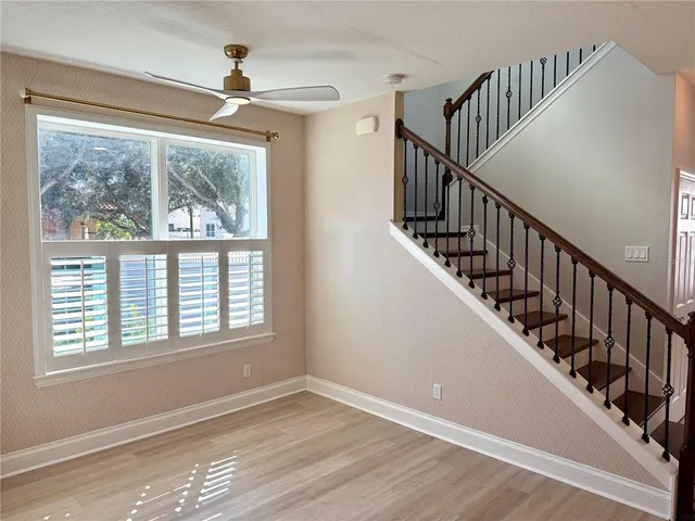 an empty room with wooden floor and windows