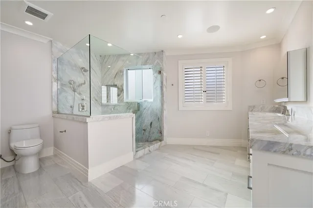 a bathroom with a granite countertop sink mirror vanity and toilet
