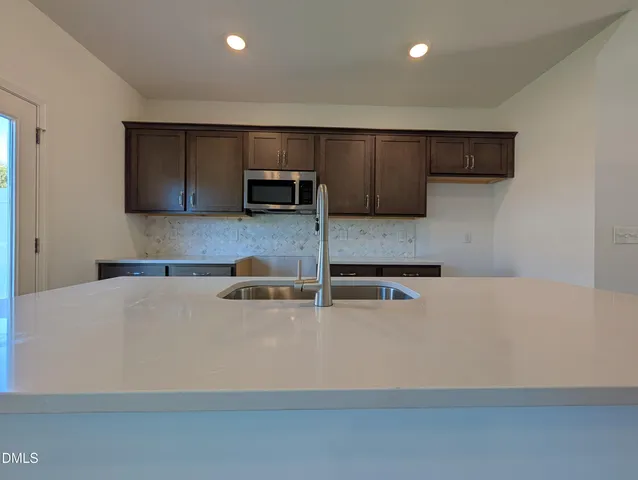 a kitchen with kitchen island a stove a sink and a refrigerator