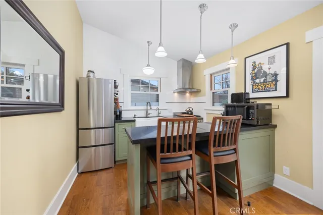 a kitchen with stainless steel appliances a refrigerator a stove a kitchen island with a dining table and chairs