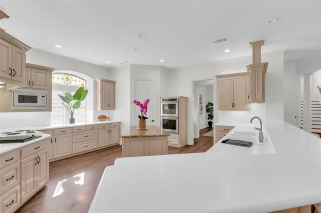 a kitchen with granite countertop a sink stainless steel appliances and window