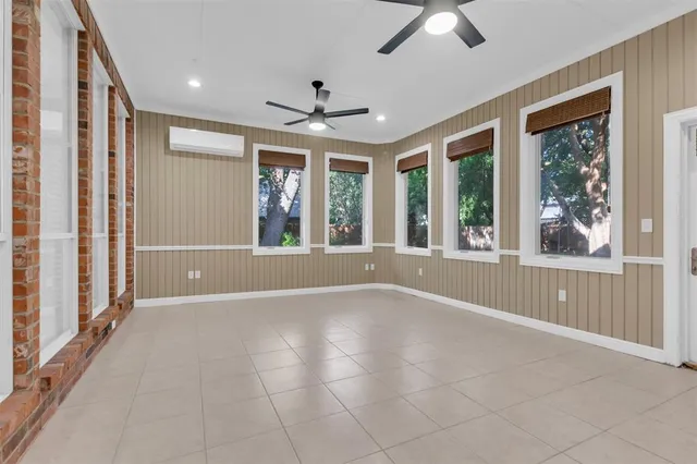 a view of an empty room with a window and a ceiling fan