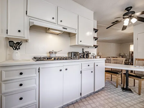 a kitchen with white cabinets and refrigerator