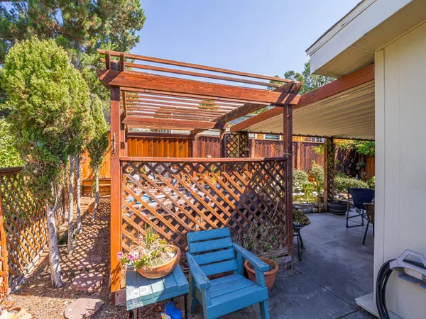 a view of patio with chairs and table under an umbrella
