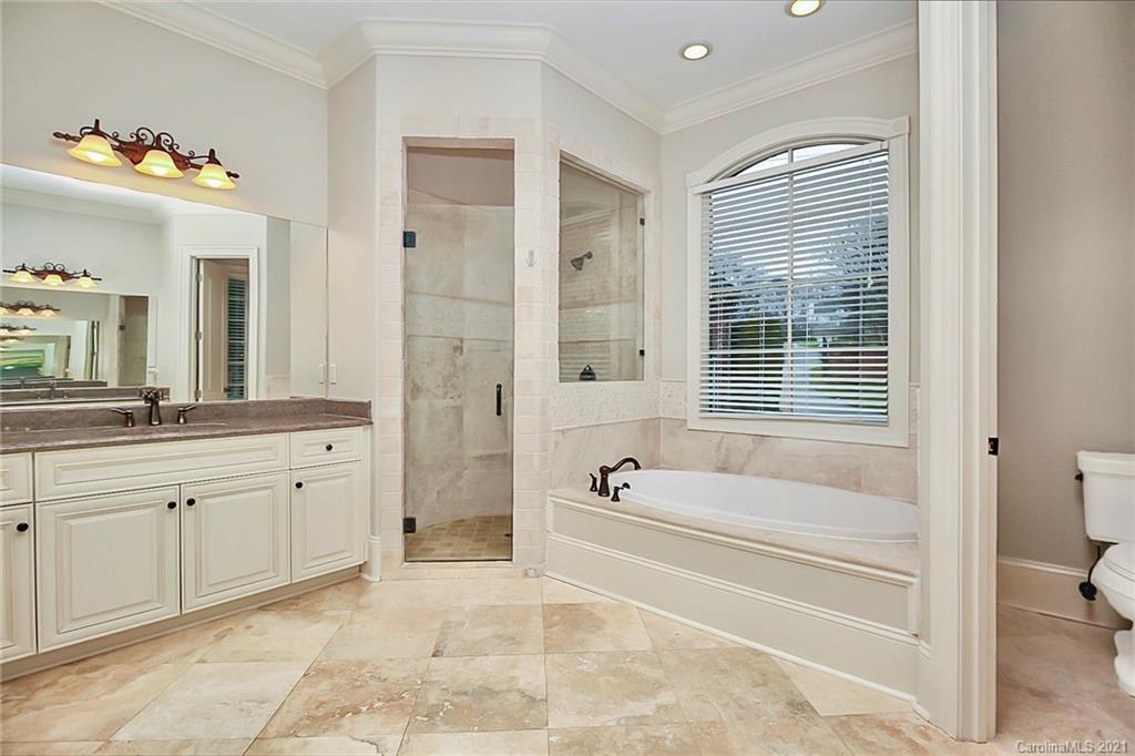 6701 Sharon Road Charlotte, NC 28210 - Photo 15 of 47 a spacious bathroom with a tub sink and mirror