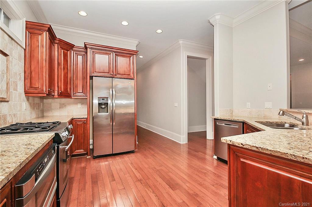 6701 Sharon Road Charlotte, NC 28210 - Photo 22 of 47 a kitchen with granite countertop wooden floors and stainless steel appliances