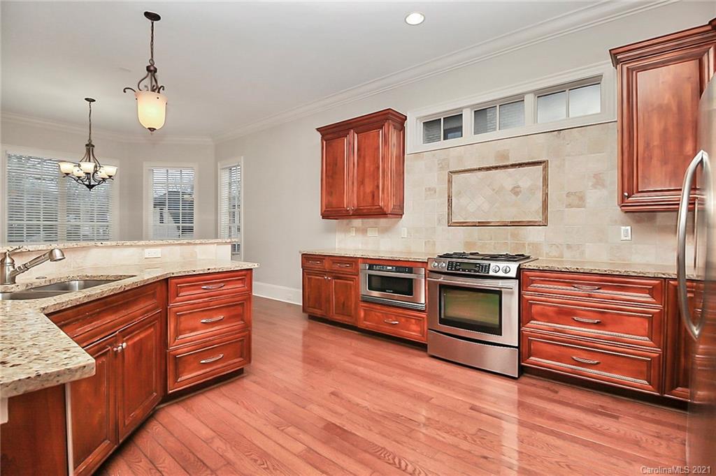 6701 Sharon Road Charlotte, NC 28210 - Photo 24 of 47 a large kitchen with stainless steel appliances granite countertop a stove a sink and a wooden floors