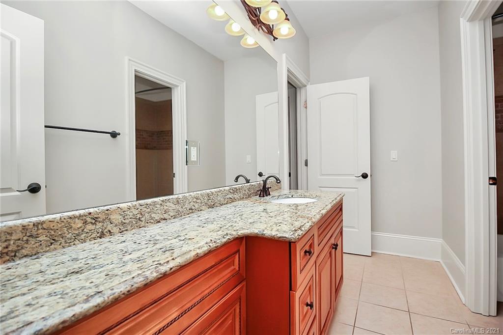 6701 Sharon Road Charlotte, NC 28210 - Photo 41 of 47 a bathroom with a granite countertop sink and a mirror