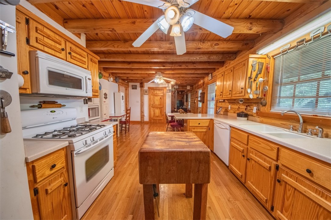 846 Twiggs Ferry Road Hartfield, VA 23071 - Photo 16 of 28 Kitchen with white appliances, light wood-style floors, light countertops, a wood ceiling with exposed beams, and a peninsula