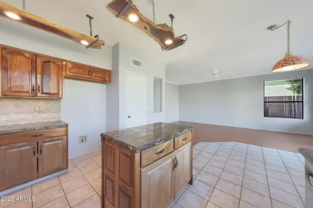 a hallway with granite countertop white cabinets and wooden floor