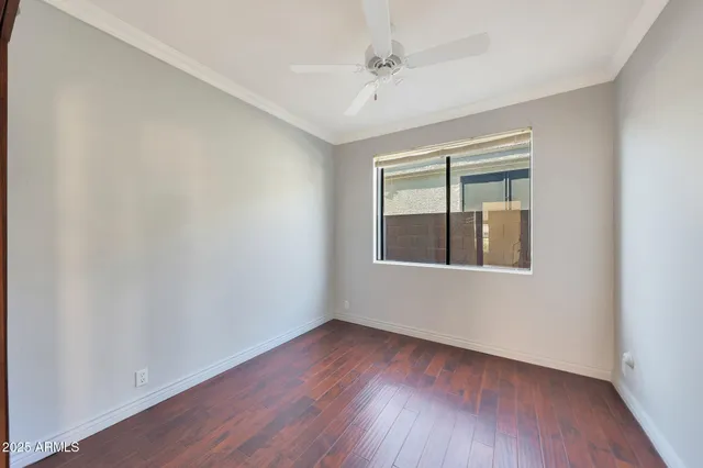 an empty room with windows and ceiling fan