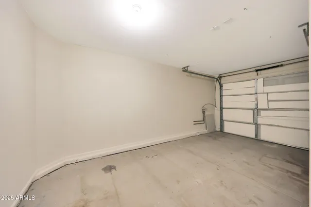 a view of an empty room with wooden floor and cabinets