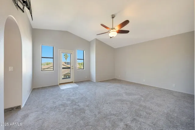 an empty room with a ceiling fan and a window