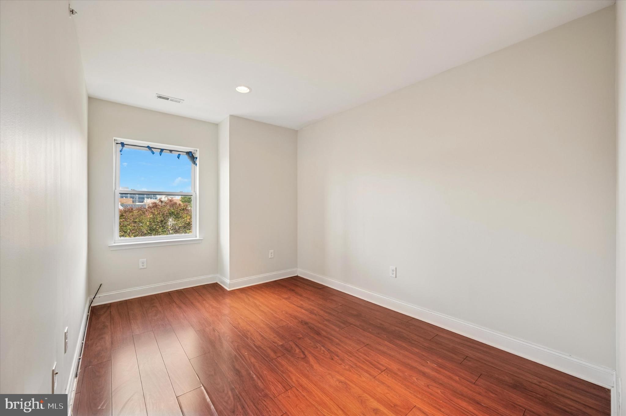 1421 North 18th Street, Unit 3 Philadelphia, PA 19121 - Photo 14 of 16 a view of an empty room with wooden floor and a window