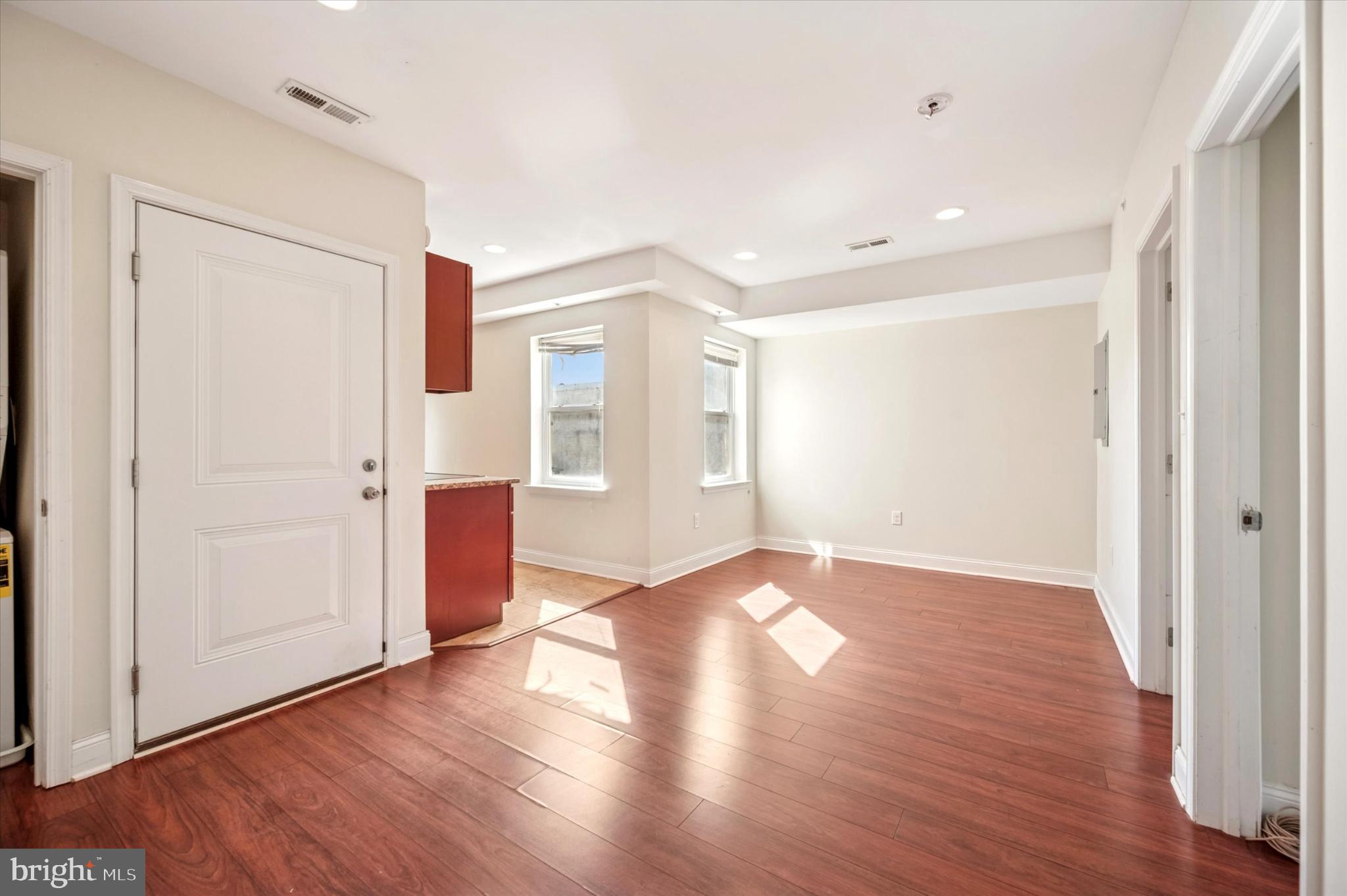 1421 North 18th Street, Unit 3 Philadelphia, PA 19121 - Photo 5 of 16 an empty room with wooden floor & windows and bathroom
