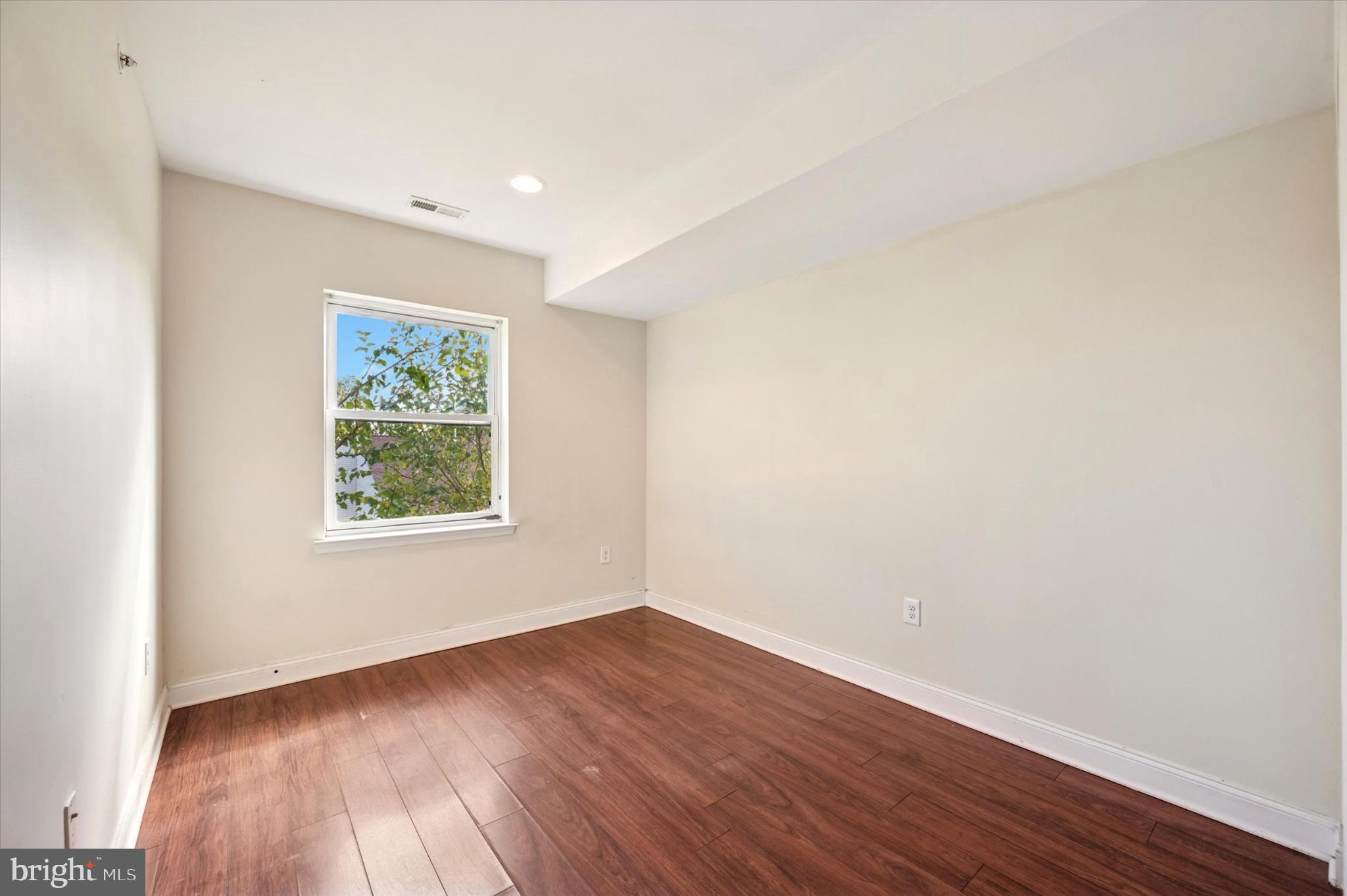 1421 North 18th Street, Unit 3 Philadelphia, PA 19121 - Photo 10 of 16 an empty room with wooden floor and window