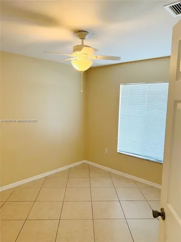 a view of a room with a hanging light and a window