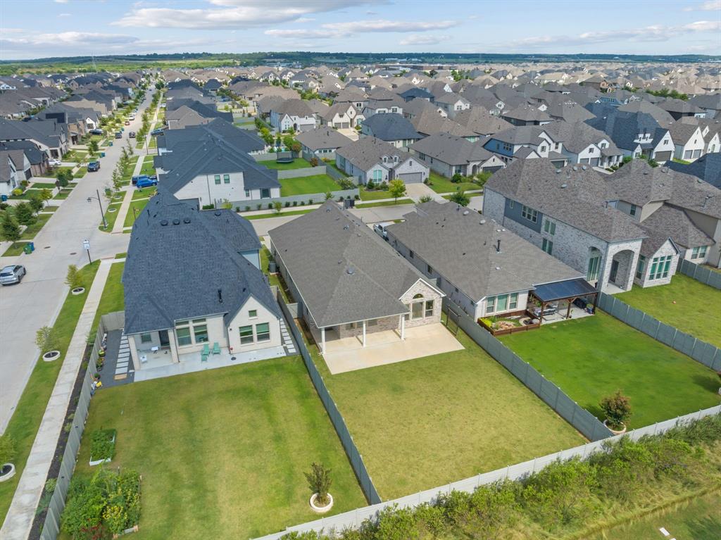 1821 Stonewall Road Argyle, TX 76226 - Photo 37 of 40 Expansive backyard featuring a large green lawn, concrete patio, and a privacy fence