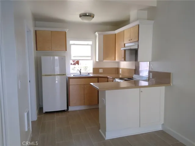 a kitchen with stainless steel appliances granite countertop a refrigerator sink and white cabinets