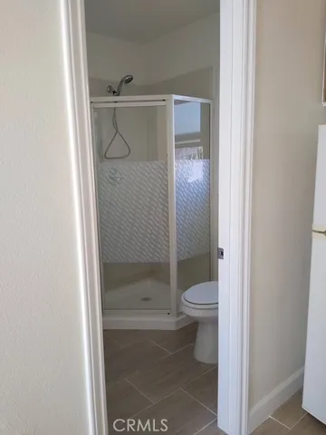 a bathroom with a granite countertop toilet and a shower