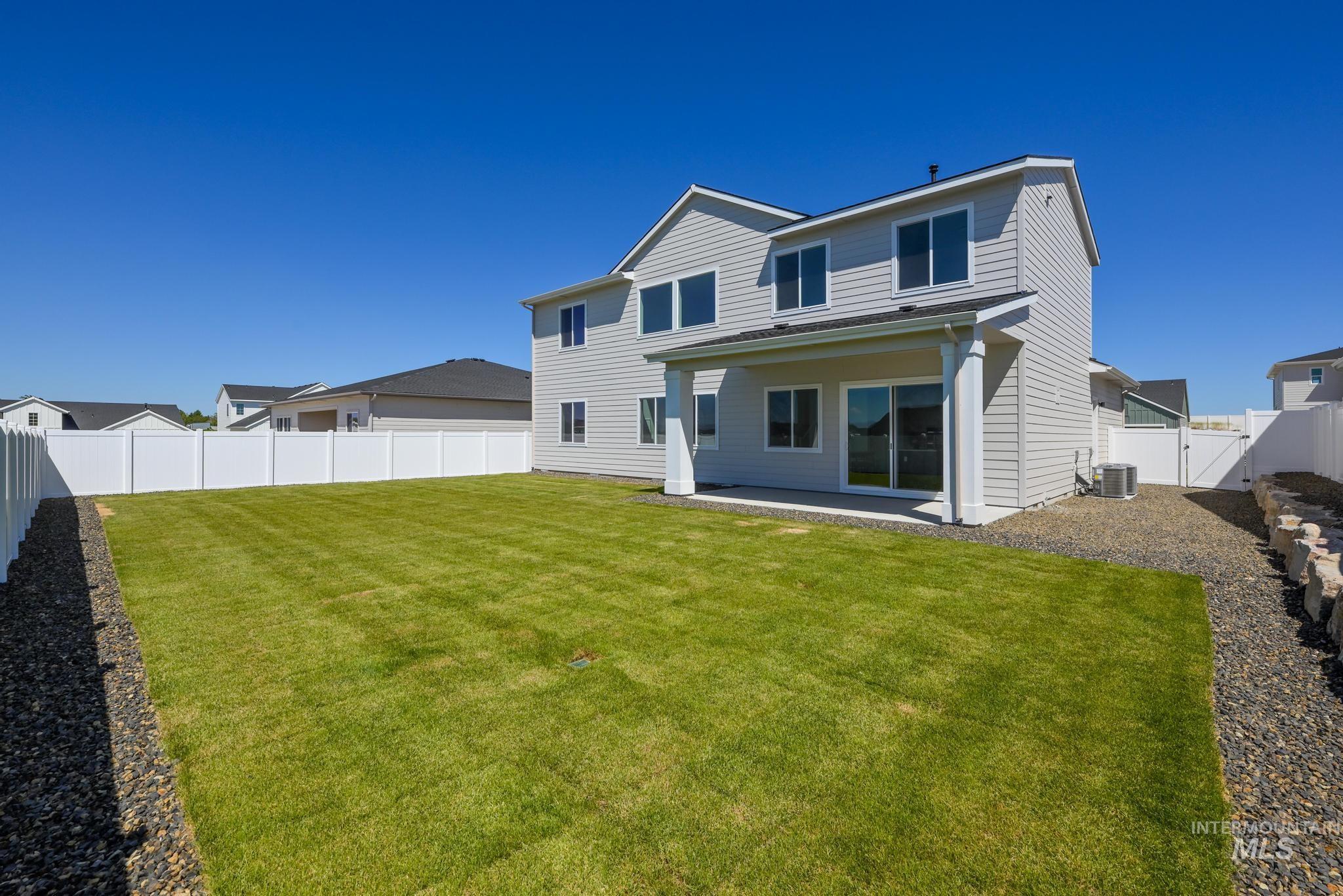 14703 Serenity Pt Street Caldwell, ID 83607 - Photo 34 of 45 Expansive backyard featuring a manicured lawn, a covered patio, and a white privacy fence