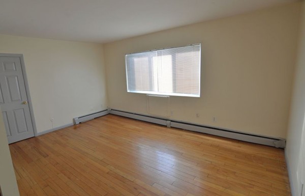 19 Winter Street, Unit 1 Boston, MA 02122 - Photo 2 of 6 an empty room with wooden floor and windows