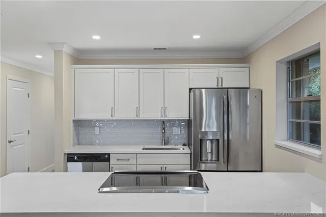 a kitchen with stainless steel appliances granite countertop a refrigerator and a stove