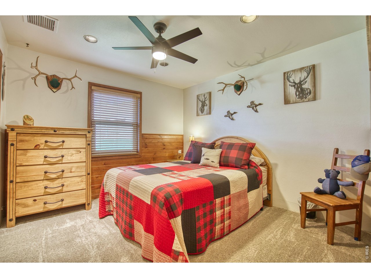 320 Del Monte Road Berthoud, CO 80513 - Photo 25 of 40 a spacious bedroom with a bed and a chandelier