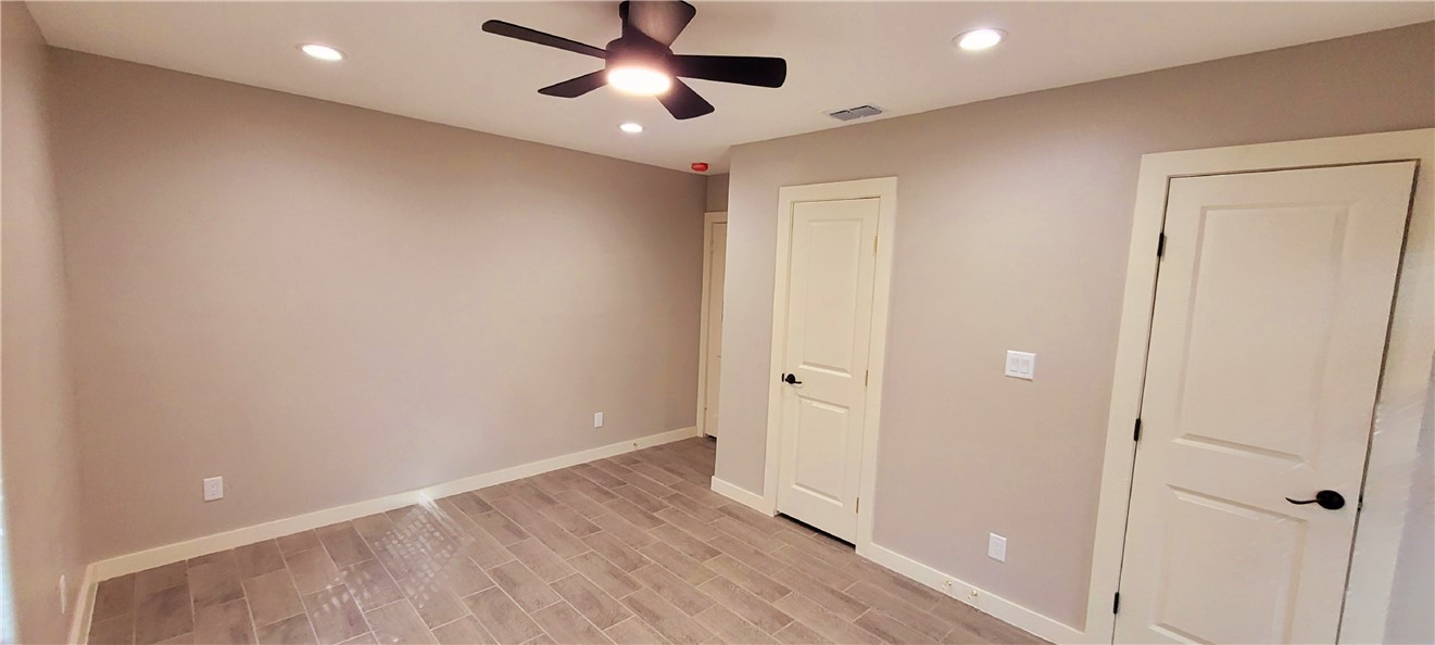 104 Hub Street Alice, TX 78332 - Photo 11 of 15 an empty room with wooden floor and windows