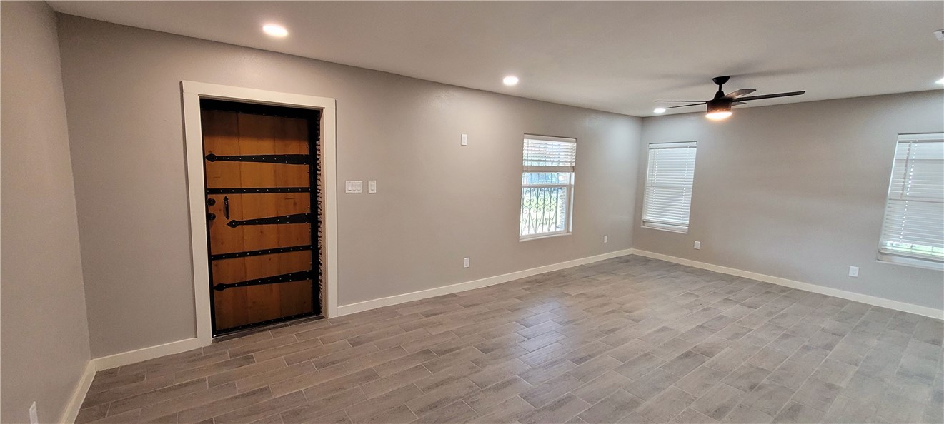 104 Hub Street Alice, TX 78332 - Photo 2 of 15 wooden floor in an empty room with a window