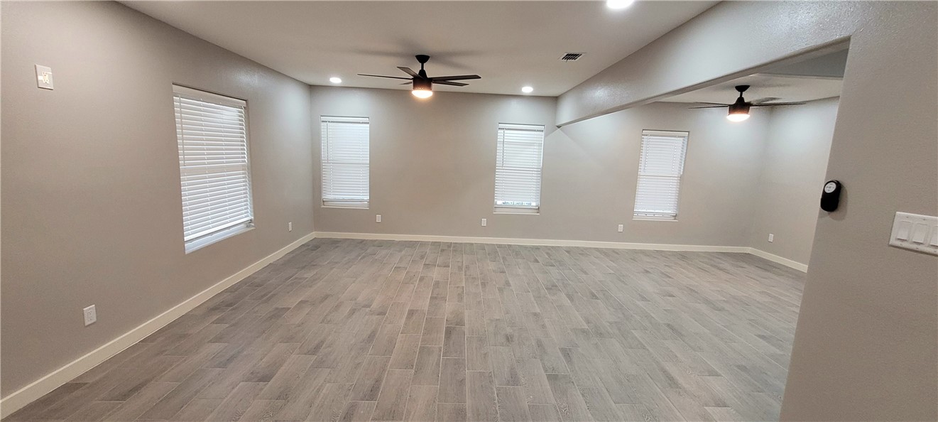 104 Hub Street Alice, TX 78332 - Photo 3 of 15 an empty room with wooden floor and windows