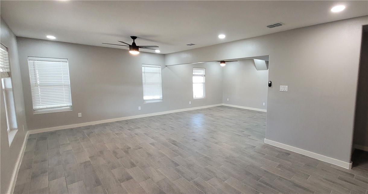 104 Hub Street Alice, TX 78332 - Photo 4 of 15 an empty room with wooden floor ceiling fan and windows