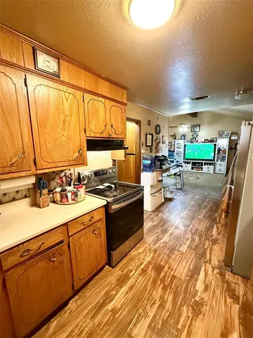 a large kitchen with a lot of counter space and wooden floor