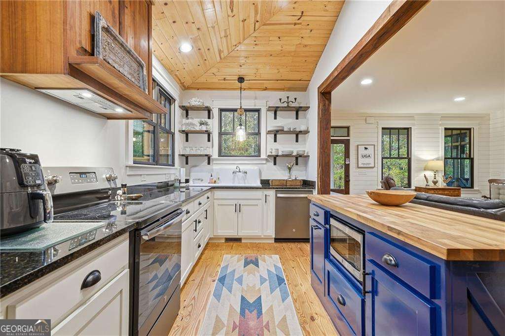 2197 Damascus Road Ball Ground, GA 30107 - Photo 21 of 39 a kitchen with stainless steel appliances granite countertop a sink and wooden cabinets