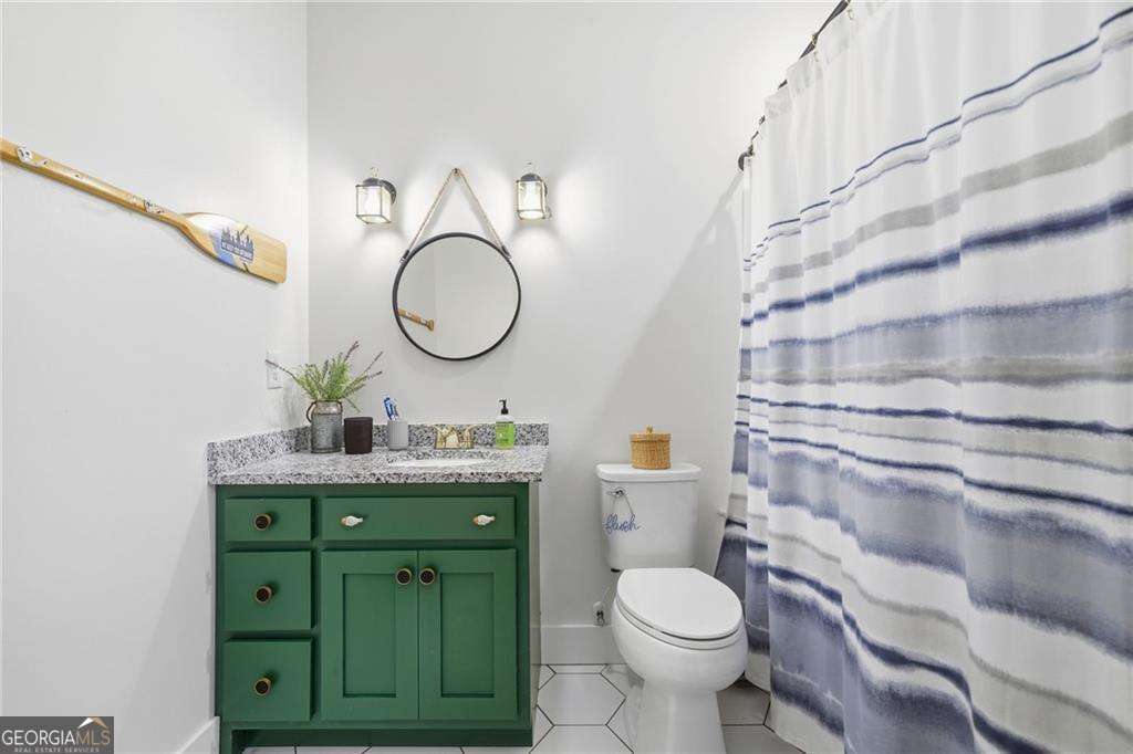 2197 Damascus Road Ball Ground, GA 30107 - Photo 34 of 39 a bathroom with a granite countertop toilet sink and mirror