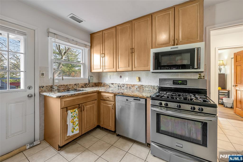 17 Porter Road West Orange, NJ 07052 - Photo 13 of 32 a kitchen with granite countertop a stove top oven microwave and cabinets