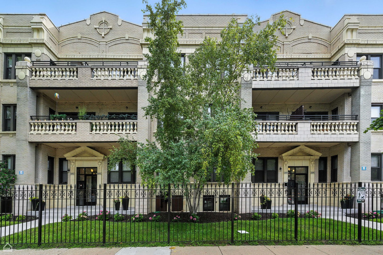 a front view of a building with a garden and entertaining space