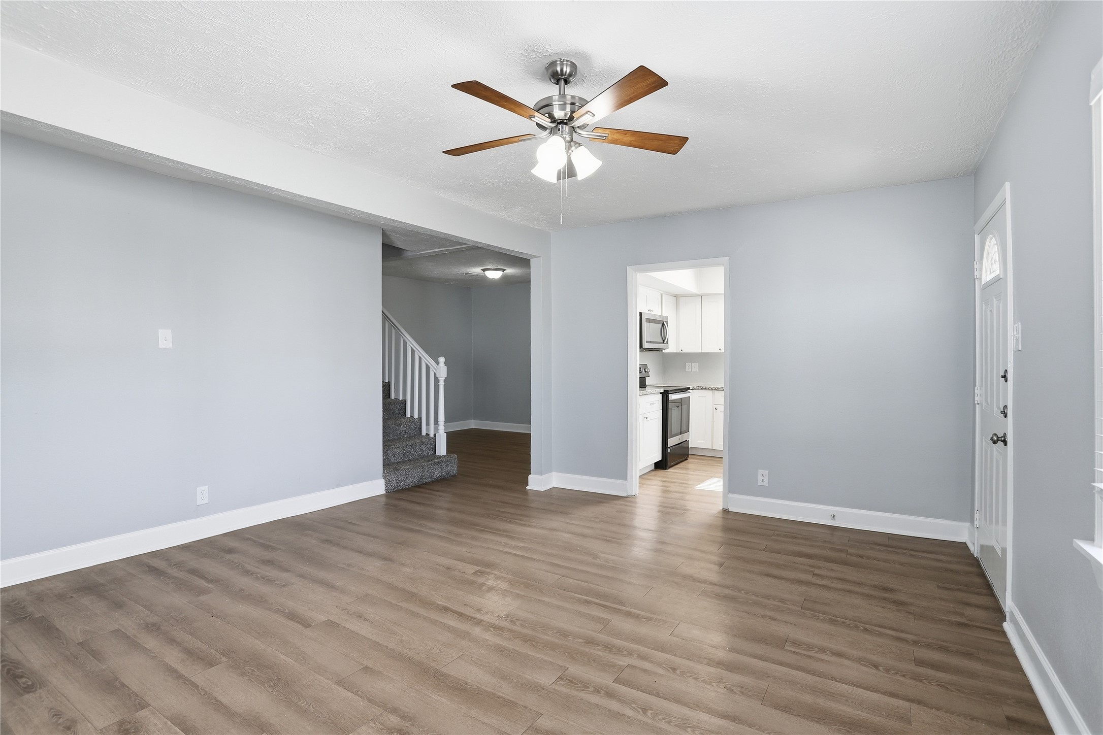 1707 Johnson Street Pasadena, TX 77502 - Photo 12 of 45 a view of an empty room with wooden floor and a ceiling fan