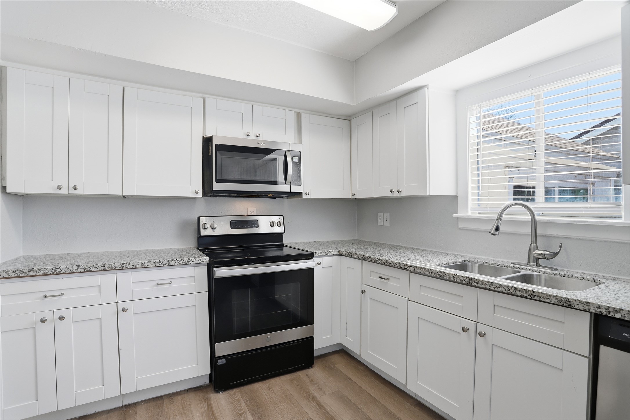 1707 Johnson Street Pasadena, TX 77502 - Photo 16 of 45 a kitchen with granite countertop white cabinets white stainless steel appliances and a sink