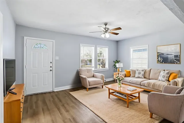 a living room with furniture a ceiling fan and a window