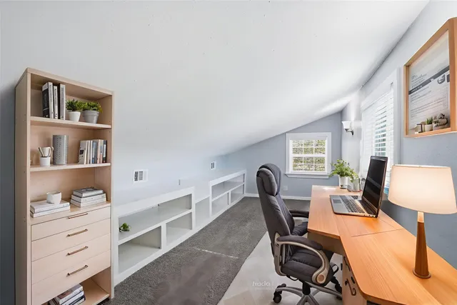 a view of a workspace with furniture and a window